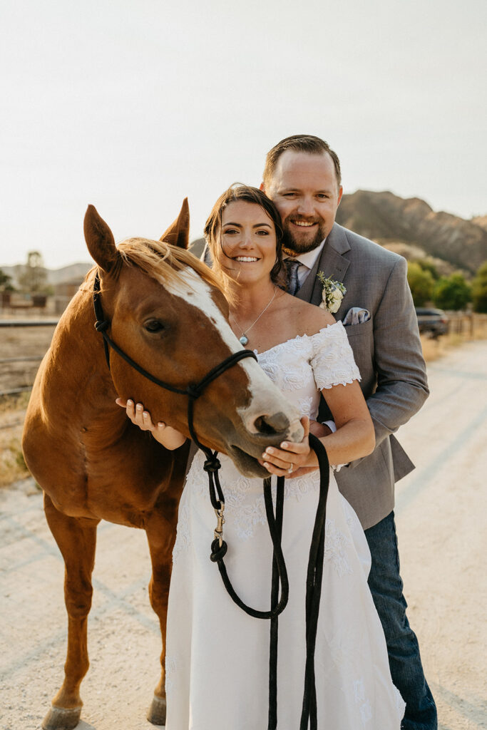 Bride and groom pose with horse for wedding portraits at BarSZ Ranch in Paicines, California