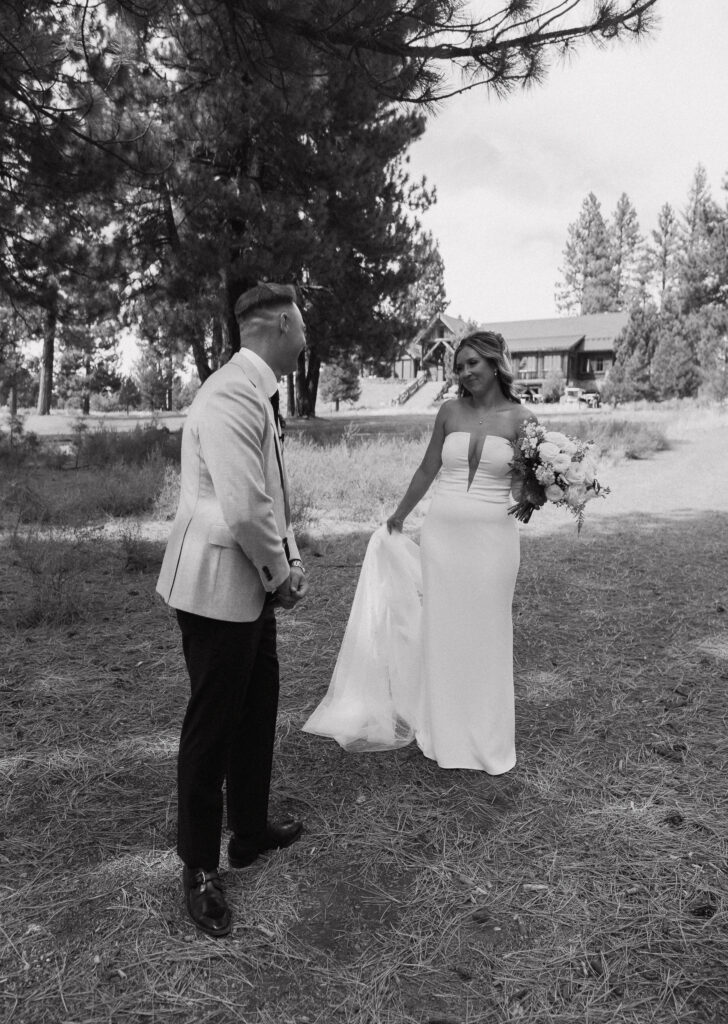 Black-and-white photo of the couple smiling at each other, showcasing the excitement of their mountain wedding near Lake Tahoe.