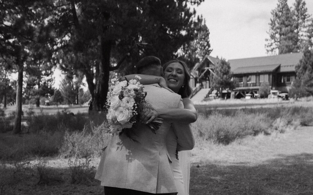 Black-and-white close-up of the newlyweds hugging, capturing a heartfelt moment amidst the rustic charm of a Tahoe Mountain Club wedding.