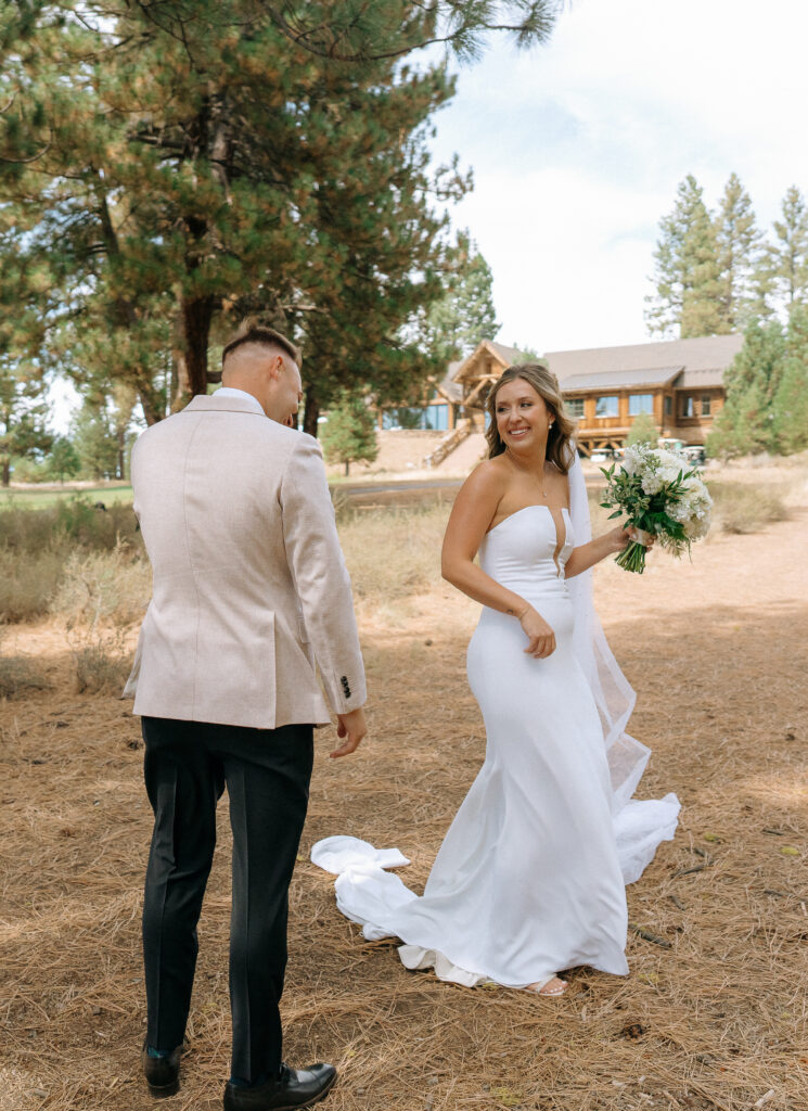 Bride turning to face the groom, bouquet in hand, surrounded by the natural beauty of a Tahoe Mountain Club ceremony site.