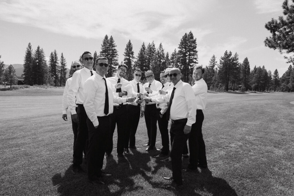 Black-and-white shot of the groom and his groomsmen on a golf course, enjoying the calm before the ceremony at Tahoe Mountain Club.
